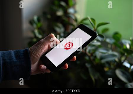 Eine Person öffnet die Pinterest App auf einem Telefon Stockfoto
