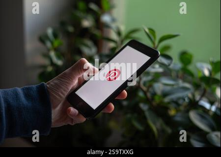 Eine Person öffnet die Pinterest App auf einem Telefon Stockfoto