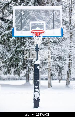 Vorderansicht des Basketballkörpers auf einem Spielplatz im Freien im Winter mit Schnee. Stockfoto