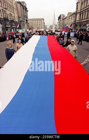 Die Russen tragen eine massive Flagge in die Twerskaja-Straße in Richtung Roter Platz, um an einer Kundgebung zur Unterstützung des russischen Präsidenten Boris Jelzin am 28. März 1993 in Moskau, Russland, teilzunehmen. Etwa 50.000 Menschen unterstützten Jelzin, nachdem das parlament es versäumt hatte, ihn im Kampf um die Reform der ehemaligen Sowjetunion zu klagen. Stockfoto