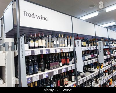Rotweingang in einem Sainsbury's Supermarkt, mit Weinflaschen aus verschiedenen Ländern, Großbritannien. Konzept: Lebenshaltungskosten, Alkoholverkauf, Diebstahl Stockfoto