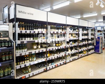 Weißweingang in einem Sainsbury's Supermarkt, mit Weinflaschen aus verschiedenen Ländern, Großbritannien. Konzept: Lebenshaltungskosten, Alkoholverkauf, Ladendiebstahl Stockfoto