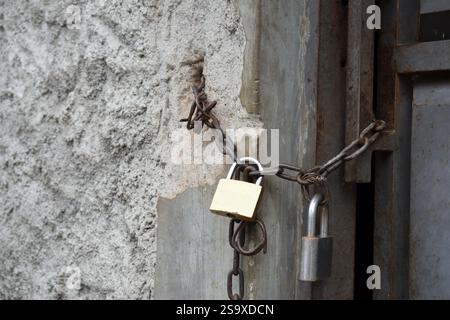 Die Tür ist mit einer Metallkette und einem Vorhängeschloss verschlossen Stockfoto