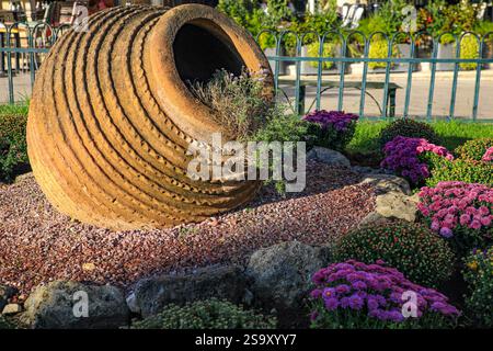 Griechenland. Großer Terrakotta-Urnenkopf in einem violetten Blumengarten Stockfoto
