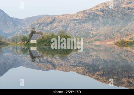 Irland, Cork, Gougane Barra. Kirchen- und Bergreflexionen im See. Stockfoto