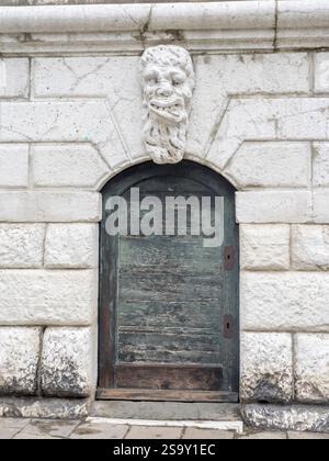 Italien, Venedig. Groteske Steinschnitzerei einer männlichen Gargoyle-Figur an der Außenseite der Kirche Santa Maria Formosa. Stockfoto