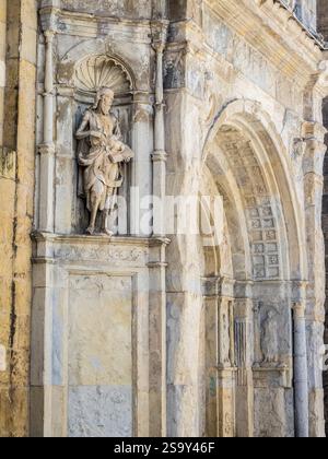 Geschnitzte Statue des heiligen Johannes des Täufers auf der Alten Kathedrale von Coimbra, einem romanischen römisch-katholischen Gebäude. Stockfoto
