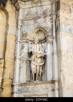 Geschnitzte Statue des heiligen Johannes des Täufers auf der Alten Kathedrale von Coimbra, einem romanischen römisch-katholischen Gebäude. Stockfoto