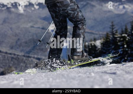 Nahaufnahme von Skifahrern und fliegendem Schnee unter Skiern, Skitour. Ansicht von unten. Wintersportkonzept, Stockfoto