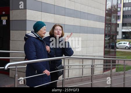 Zwei ältere Damen, Mutter und Tochter, laufen durch die Stadt, reden, lachen, trinken Kaffee. Aktiver gesunder Lebensstil Stockfoto