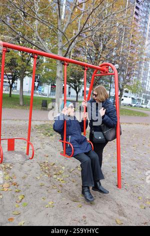 Zwei ältere Damen mit Fahrt auf Schaukeln im Park, älteren Freunde, Ruhestand Stockfoto