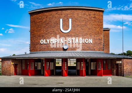 Der Eingang der U-Bahn-Station Olympia-Stadion mit einer großen Ziegelfassade mit einem auffälligen U-Schild. Der Himmel ist klar und blau. Stockfoto