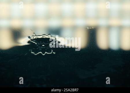 Tropfen spritzen Krone im Wasser mit Licht im Hintergrund Stockfoto
