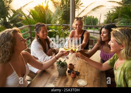Eine Gruppe verschiedener Frauen, die im Restaurant sitzen und mit Weingläsern anstoßen. Genießen Sie eine Weinprobe. Frauentreffen, Freundschaftsfeier. Entspannend Stockfoto