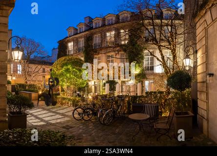 Paris, Frankreich - 01 11 2025: Place des Vosges. Sehen Sie die Fassade des Queen's Pavilion Hotels mit weihnachtsdekoration bei Nacht Stockfoto