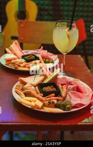 Eine vertikale Aufnahme einer Platte mit verschiedenen Käsesorten, Salami und anderen Speisen Stockfoto