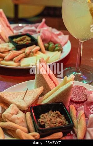 Eine vertikale Aufnahme einer Platte mit verschiedenen Käsesorten, Salami und anderen Speisen Stockfoto