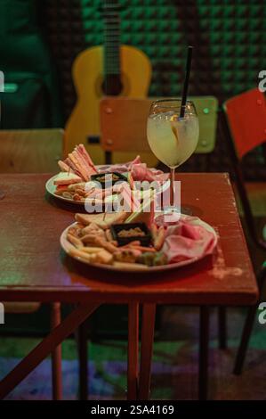 Eine vertikale Aufnahme einer Platte mit verschiedenen Käsesorten, Salami und anderen Speisen Stockfoto
