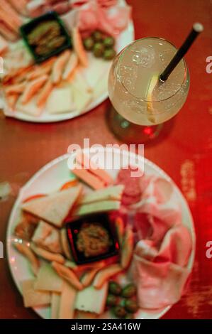 Eine vertikale Aufnahme einer Platte mit verschiedenen Käsesorten, Salami und anderen Speisen Stockfoto