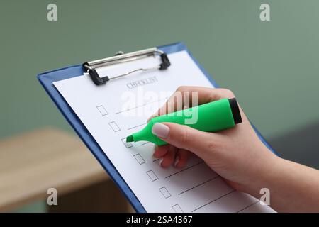 Frau, die die Checkliste drinnen überprüft, Nahaufnahme Stockfoto