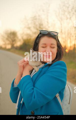 Eine junge Frau, die eine süße kleine Katze hält Stockfoto