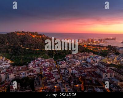 Blick auf die Burg Gibralfaro in Malaga, Spanien, bei Sonnenuntergang mit farbenfrohem Himmel Stockfoto