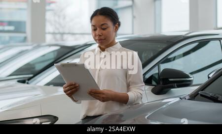 Afroamerikanische ethnische Frau Verkäuferin Berater Händler Autohändler Hilfe, um Auto im Händlergeschäft lächelnd glücklich Mädchen zu wählen Stockfoto
