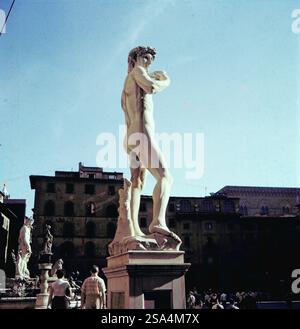 Eine Replik von Michelangelos David auf der Piazza della Signoria in Florenz, im Hintergrund erkennbar der Neptunbrunnen, die Statue von Judith und Holofernes sowie eine Kopie von Donatellos Marzocco, dem Löwen, der Florentiner Stadtwappen hält, Italien 1956. Eine Nachbildung von Michelangelos David auf der Piazza della Signoria in Florenz, mit dem Neptunbrunnen im Hintergrund, der Statue von Judith und Holofernes und einer Kopie von Donatellos Marzocco, dem Löwen mit dem florentinischen Wappen, Italien 1956. Stockfoto