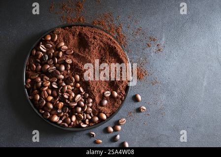 Geröstete Kaffeebohnen und gemahlener Kaffee auf grauem Hintergrund. Kopierbereich. Direkt darüber Stockfoto