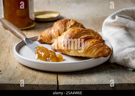 Frisch gebackene Croissants auf rustikalem Holztisch Stockfoto