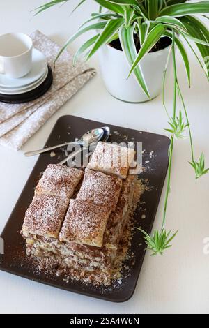 Köstliches Mille-Feuille-Dessert mit Schokoladencreme und Staubzucker auf weißem Holztisch. Direkt darüber. Kopierbereich. Stockfoto