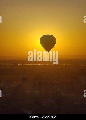 Sie treiben über das Tal der Könige, umarmt vom goldenen Glanz des Sonnenaufgangs. Stockfoto