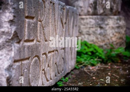 Detail einer verlassenen Steinplatte mit einer alten lateinischen Inschrift, Rom, Italien Stockfoto
