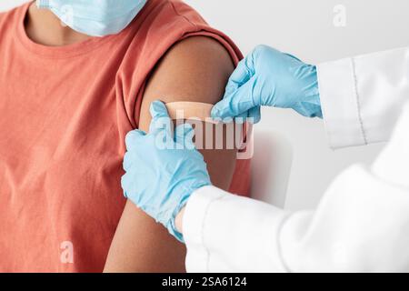 Krankenschwester, die medizinischen Pflaster auf den weiblichen Patientenarm legt Stockfoto