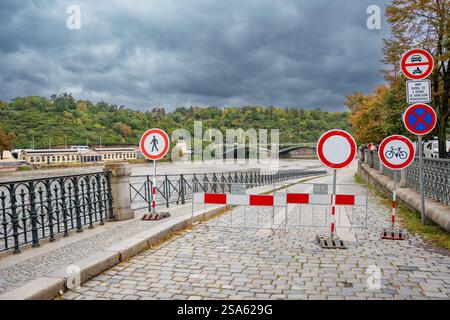 Straßenschilder, die darauf hinweisen, dass der Zugang zum Damm verboten ist. Überschwemmung in Prag. Blick auf die Brücke über die überflutete Moldau, Prag Stockfoto