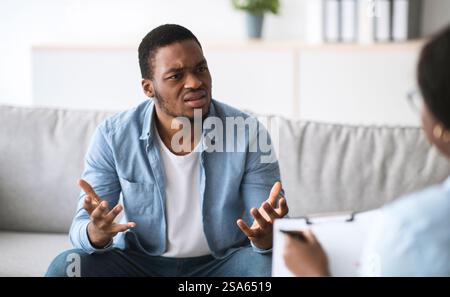 Psychologe hilft depressiven jungen schwarzen Mann, Beratung zu männlichen Patienten im Büro Stockfoto