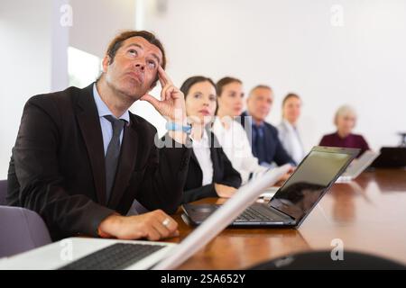 Geschäftsmann mit Blick auf die Decke bei Geschäftstreffen im Tagungsraum Stockfoto