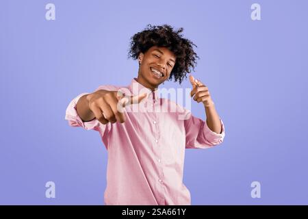 Sie sind dran. Fröhlicher afroamerikanischer Kerl, der mit den Fingern auf die Kamera zeigt und lächelt und dich vor blauem Hintergrund auswählt Stockfoto
