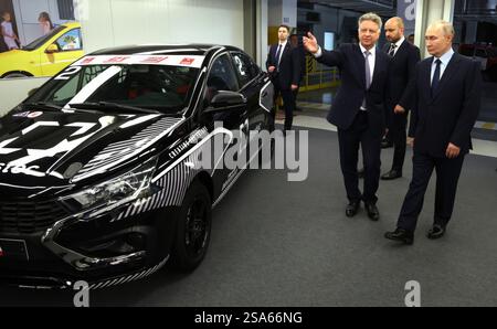 Togliatti, Russland. Januar 2025. Der russische Präsident Wladimir Putin, rechts, zeigt den Prototyp des Lada-Fahrzeugs von AvtoVAZ-Präsident Maxim Sokolov, Zentrum, während einer Tour durch die Automobilproduktion im Werk Tolyatti am 28. Januar 2025 in Togliatti, Oblast Samara, Russland. Quelle: Vyacheslav Prokofyev/Kreml Pool/Alamy Live News Stockfoto