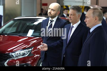 Togliatti, Russland. Januar 2025. Der russische Präsident Wladimir Putin, rechts, zeigt den Prototyp eines Lada Iskra-Fahrzeugs von AvtoVAZ-Präsident Maxim Sokolov, Zentrum, und dem Gouverneur der Region Samara, Vyacheslaw Fedorishchev, links, während eines Rundgangs durch die Automobilproduktion im Werk Tolyatti am 28. Januar 2025 in Togliatti, Oblast Samara, Russland. Quelle: Vyacheslav Prokofyev/Kreml Pool/Alamy Live News Stockfoto