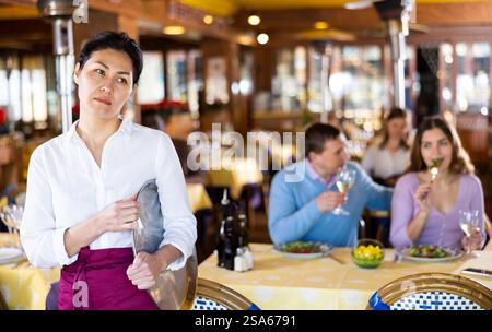 Porträt der verärgerten Kellnerin im Saal des Restaurants Stockfoto