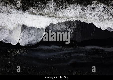Aus der Vogelperspektive sehen Sie epische Meereswellen, die am schwarzen Strand Reynisfjara in Island im VIK Myrdal im Golden Circle Gebiet abstürzen Stockfoto