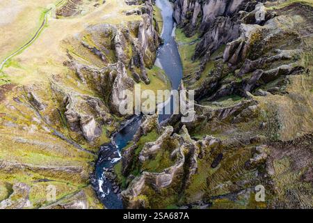 Atemberaubender Blick über die Drohne auf einen ruhigen Fluss, der sich durch einen majestätischen Fjadrargljufur Canyon in Island schlängelt Stockfoto