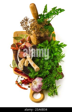 Gewürze und Kräuter in einem Mörser auf weißem Hintergrund Stockfoto