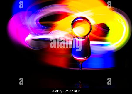 Abstrakte Szene mit einem Glas Wasser und einem regenbogenfarbenen Hintergrund Stockfoto
