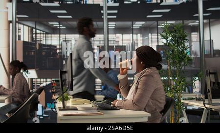 afroamerikaner müde Geschäftsmitarbeiter arbeiten hart an der Erfüllung der Unternehmensziele und spüren den Druck und Burnout beim Erreichen der Ziele. Die junge Managerin fühlt sich erschöpft. Kamera B.. Stockfoto