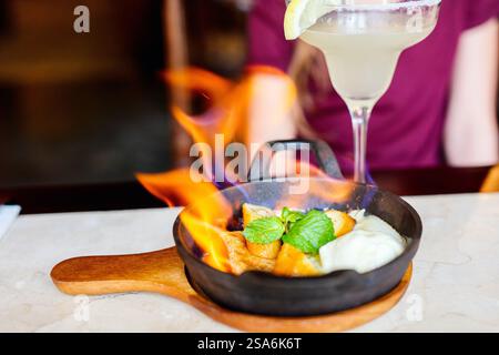 Bananenflambe mit Rum und gereiftem Honig, serviert über Pfannkuchen und Vanilleeis Stockfoto