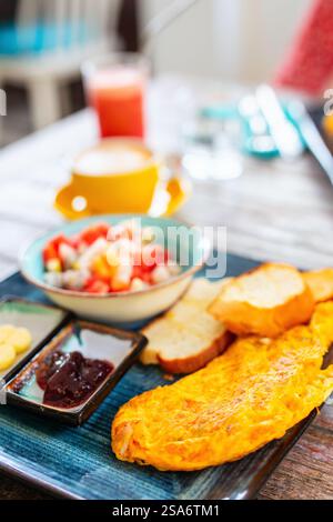 Leckeres Frühstück mit Omelette, Toast und Obstsalat Stockfoto