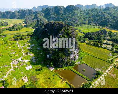 Aus der Vogelperspektive von Tam Coc in der Nähe von Ninh Binh in Vietnam mit einer atemberaubenden Landschaft von Reisfeldern zwischen Kalksteinfelsen, die oft als Halong-Bucht an Land bezeichnet werden Stockfoto