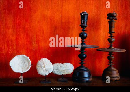 Nahaufnahme von Kerzenhaltern und Muscheln vor orangefarbenem Hintergrund Stockfoto